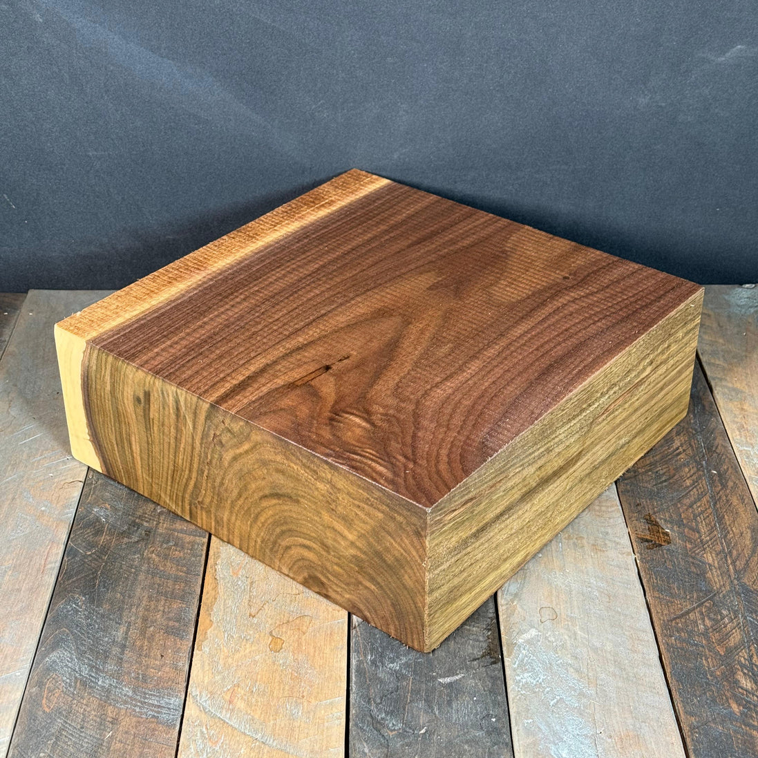 Wooden block on a rustic wooden surface with a dark background