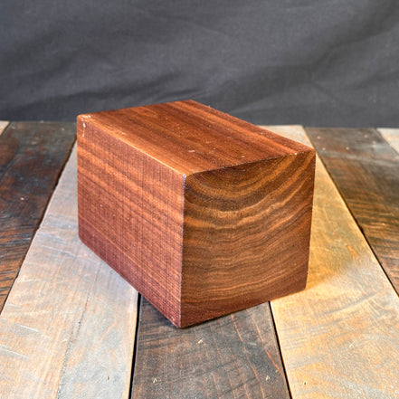 Wooden block with a geometric design on a dark fabric background