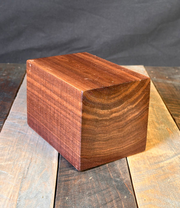 Wooden block with a geometric design on a dark fabric background
